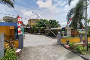 une rue avec un bâtiment avec un chat dans le chapeau dans l'établissement Urbanview Hotel Yasminstar Muntok, à Kelian