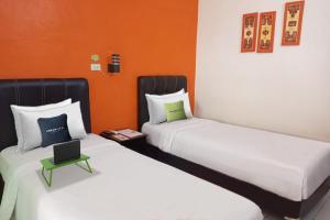 Tempat tidur dalam kamar di Urbanview Hotel Yasminstar Muntok