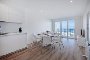 a white kitchen and dining room with a table and chairs at Nahia in Hendaye
