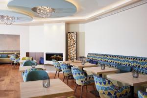 a restaurant with wooden tables and blue chairs at Sporthotel Zum Hohen Eimberg in Willingen