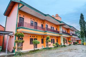 un edificio naranja con balcones y plantas. en Capital O 92316 Wisma Widya Loka Pratama, 