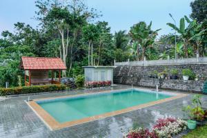 una piscina en un patio con cenador en Capital O 92316 Wisma Widya Loka Pratama, 