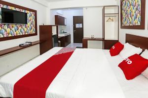 - une chambre avec un grand lit et des oreillers rouges dans l'établissement OYO 92317 Apartment Riverview By Alima View, à Bekasi