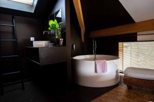 a bathroom with a large white tub in a room at La Métairie du Clos Saint Louis in Montréal