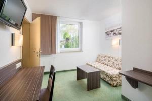 ein Wohnzimmer mit einem Sofa und einem Tisch in der Unterkunft Hotel zur Post in Hemmingen