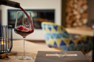 a glass of red wine being poured into it at Sporthotel Zum Hohen Eimberg in Willingen