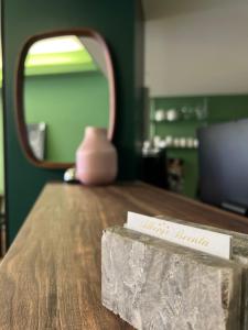 a sign on top of a wooden table with a mirror at Hotel Brenta in Parma