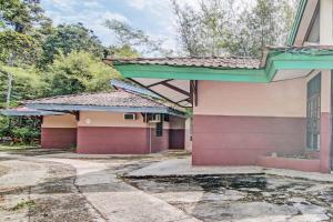 una casa vieja con morado y verde en OYO 92331 Rindu Sempadan Cottage en Pekanbaru