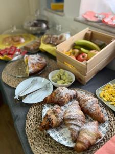 a table with plates of pastries and a box of fruit at Hotel Brenta in Parma