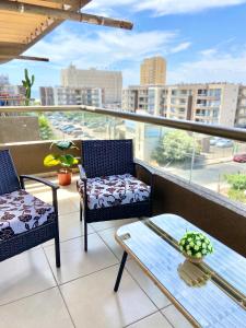 a balcony with two chairs and a table and a view at Apartamentos Alma Socoroma in Arica