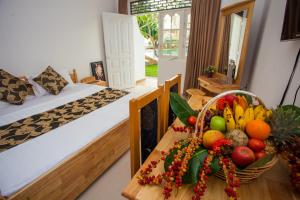 a room with two beds and a basket of fruit on a table at Navro Beach Resort in Panadura