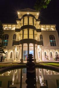 a building with a fountain in front of it at night at Navro Beach Resort in Panadura