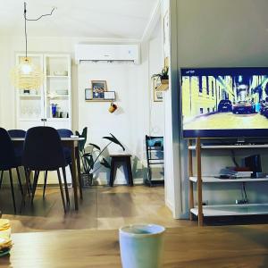 a living room with a flat screen tv and a table at Summarhús29 in Tvøroyri