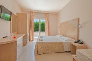 a bedroom with a bed and a kitchen with a television at Hotel Villaggio Cala Di Volpe in Capo Vaticano