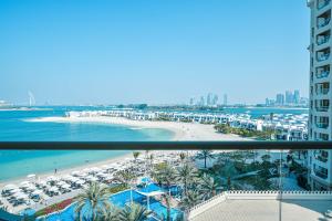 a view of a beach and the ocean from a balcony at Palm Jumeirah's Spectacular Ocean-View Apartment - NBT in Dubai