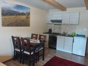 a kitchen with a table and chairs in a room at Pokoje Gościnne U Jaśka in Ząb