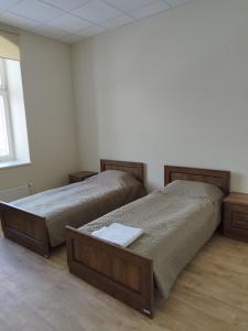 2 bedden in een witte kamer met 2 bedden van 6 x 7 cm bij Eglutė in Šilutė