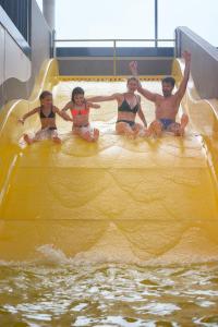 a group of people sitting on a ride in a water slide at Familotel Schreinerhof in Schönberg