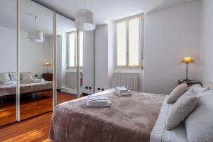 ein weißes Schlafzimmer mit einem Bett und einem Spiegel in der Unterkunft CASA VACANZE ANNA in Bergamo