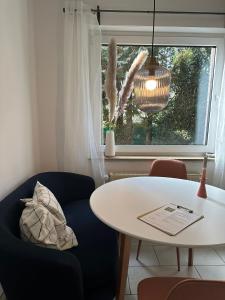 Zimmer mit einem Tisch, einem blauen Stuhl und einem Fenster in der Unterkunft Die Ibbenbürener Ferienstube in Ibbenbüren