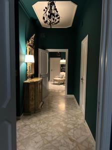 un pasillo con una habitación con paredes verdes y una lámpara de araña en Interno 9 en Bari