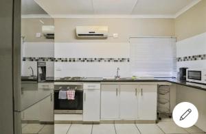 een keuken met witte kasten en een aanrechtblad bij St Lucia Safari Logde Holiday Home in St Lucia