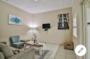 een woonkamer met een bank, een tafel en een tv bij St Lucia Safari Logde Holiday Home in St Lucia