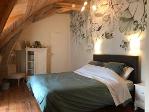 a bedroom with a bed with a painting on the wall at La Saulainière in Pontlevoy