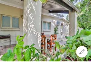 een veranda van een huis met een tafel en stoelen bij St Lucia Safari Logde Holiday Home in St Lucia