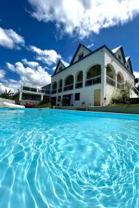 een huis met een zwembad ervoor bij Villa Blue Lodge in Saint-Louis