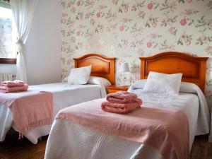 2 camas con toallas en una habitación en Finca La Cuesta, en Cangas de Onís