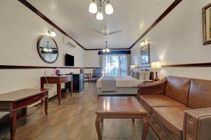 a living room with a couch and a bed at Citrus Chambers Mahabaleshwar in Mahabaleshwar