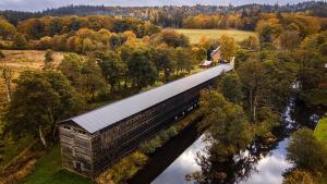 een gebouw met een dak op een brug over een rivier bij The Cottage in Brædstrup