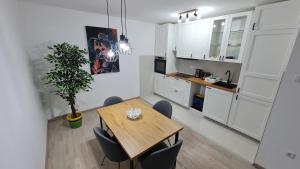 kuchnia i jadalnia z drewnianym stołem i krzesłami w obiekcie PABLO PICASSO Premium Apartman w Niszu