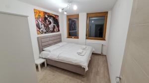 a small bedroom with a bed and a window at PABLO PICASSO Premium Apartman in Niš