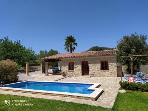 a villa with a swimming pool in front of a house at Casa Villa Las Encinas in Pollença