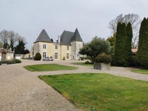 una casa grande con una entrada delante de ella en Château de La Vallade, en Saint-Porchaire