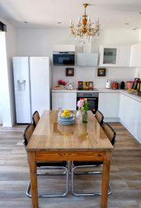 - une cuisine avec une table à manger en bois et des chaises dans l'établissement LA MAISON d'HORTENSE, maison de charme et de caractère, à Toulouse