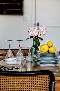 a dining room table with plates and a vase of flowers at LA MAISON d'HORTENSE, maison de charme et de caractère in Toulouse