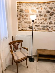 eine Lampe und ein Stuhl in einem Zimmer in der Unterkunft Αυλή in Nafplio