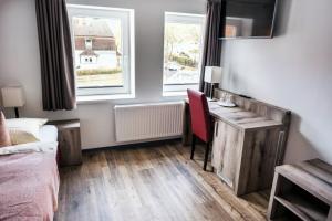 sypialnia z łóżkiem i biurkiem oraz dwoma oknami w obiekcie Galeriehotel Maribondo w mieście Worpswede +8 zdjęć