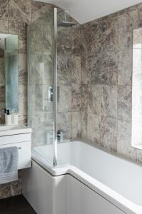 a white bathroom with a tub and a sink at Lovely House in Welwyn with Garden and Off road parking in Welwyn Garden City