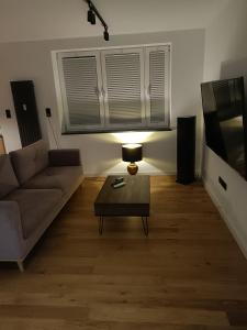a living room with a couch and a table and a tv at Apartament 3 Maja 4 in Gorlice