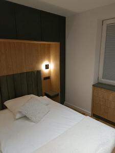 sypialnia z białym łóżkiem i oknem w obiekcie Apartament 3 Maja 4 w Gorlicach
