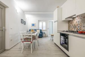 a kitchen with a table and a dining room at AffittaSardegna-Casa Altamarea in Cala Gonone