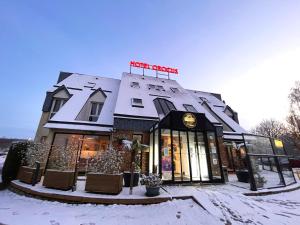 uma loja na neve em frente a um edifício em Hôtel Crocus Caen Mémorial em Caen