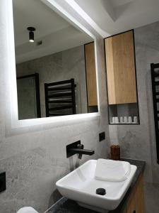 a bathroom with a white sink and a mirror at Apartament 3 Maja 4 in Gorlice