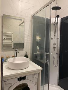 a white bathroom with a sink and a shower at Lovely studio - heart of Menton, near the beach. in Menton