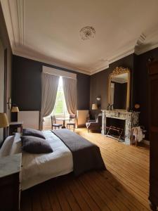 een slaapkamer met een groot bed en een spiegel bij B&B 't Kasteel & 't Koetshuys in Veurne