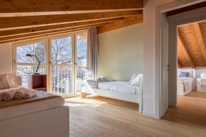 sypialnia z 2 łóżkami i oknem w obiekcie Apartment Tulipani 9 – Tremezzina w mieście Tremezzo